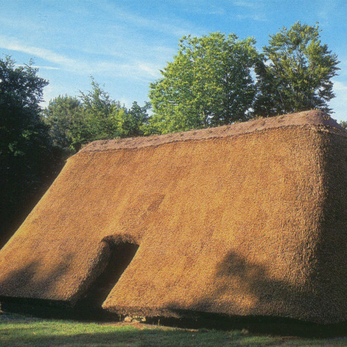 Reconstruction de la maison de Melrand : toit de chaume descendant presque jusqu’au sol