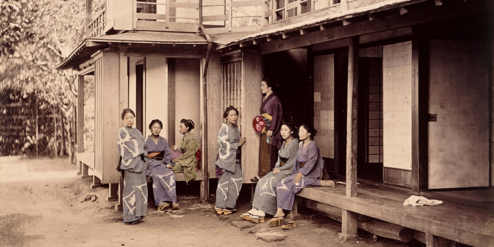 Groupe de sept femmes devant une maison