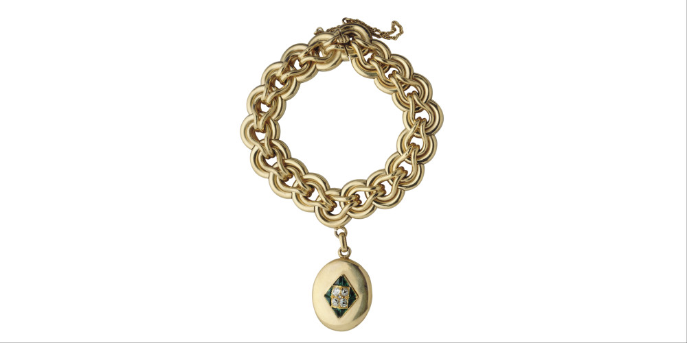 Bracelet constitué d'une large chaine forçat, avec un pendentif circulaire orné de pierres vertes et de brillants contenant une mèche de cheveux sous verre