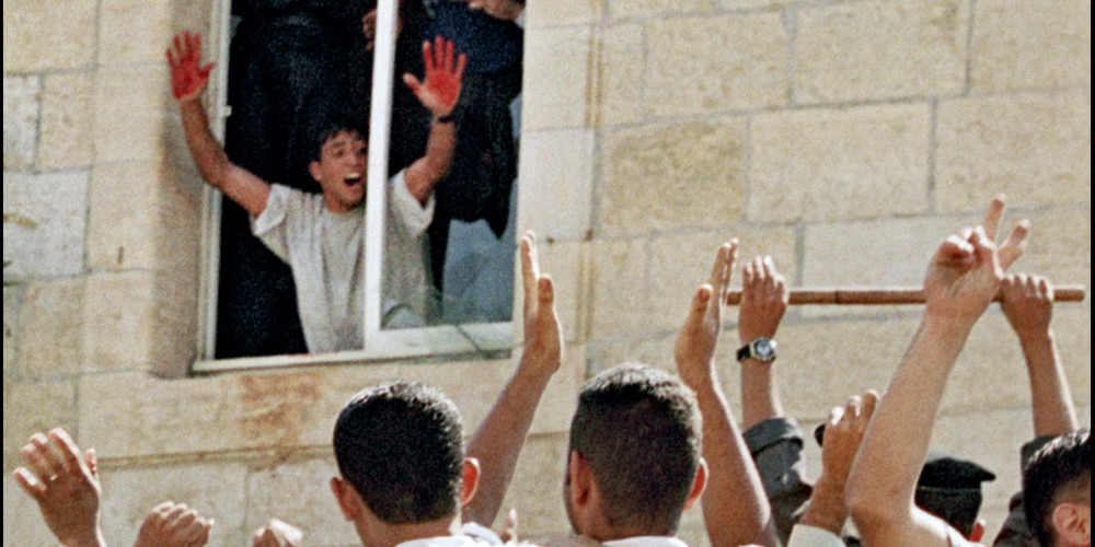 Un jeune Palestinien montre ses mains couvertes de sang