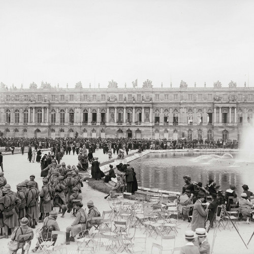 Foule autour des parterres d’eau du château de Versailles, présence de soldats français, le jour de la signature du traité de Versailles